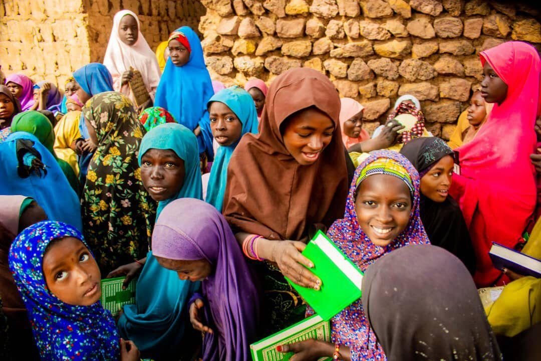 Girls in Wamako holding the Qurans they have just received
