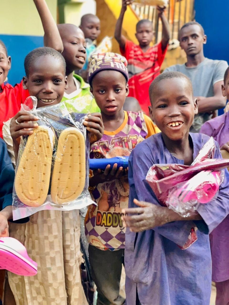 Children at the centre holding up gifts they received