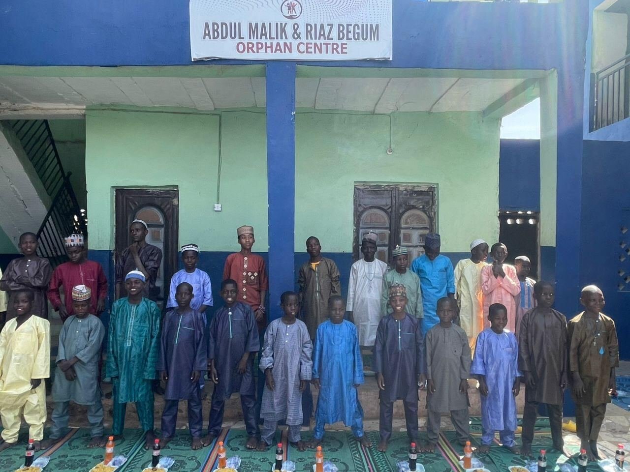 Orphans standing in front of the centre sign