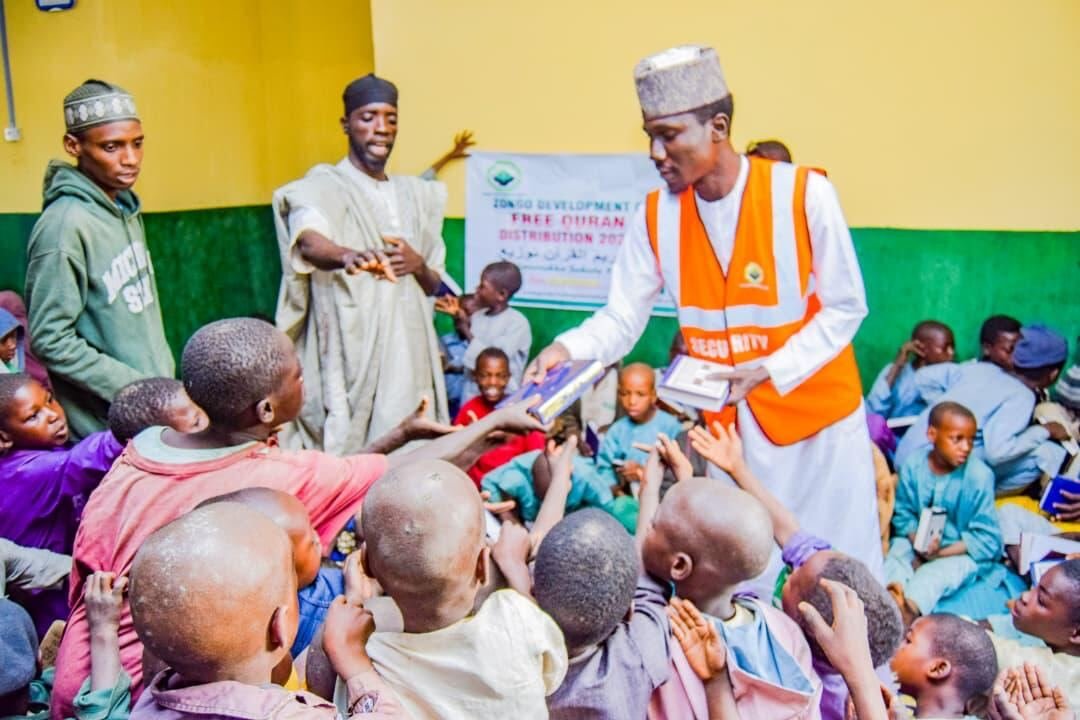 A teacher handing books to children