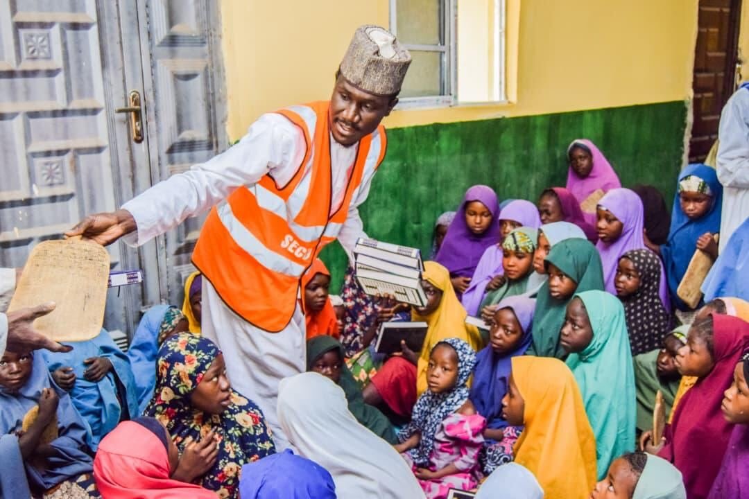 A volunteer handing out Qurans